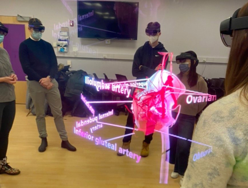 Medical students wearing VR goggles to see a 3D heart illustration